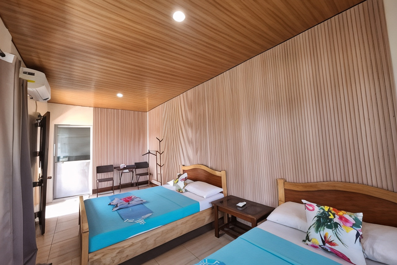 Family Room at Happy's Homestay — wood paneling and teal bedding